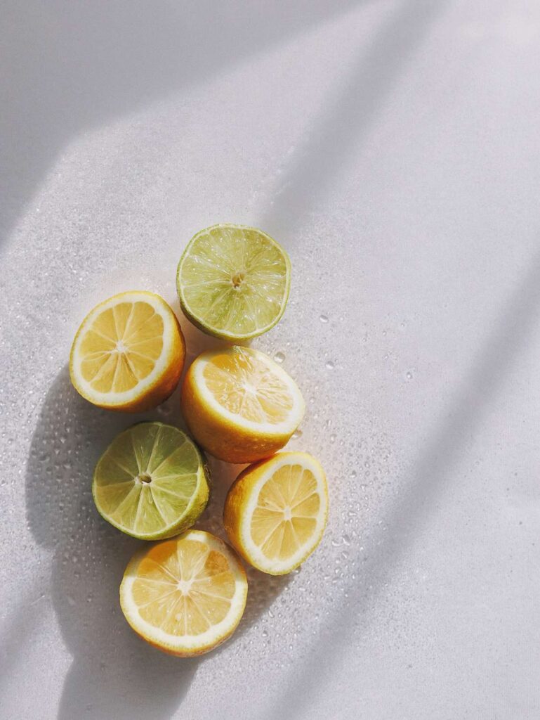 A close up of lemons and limes on a white table.
