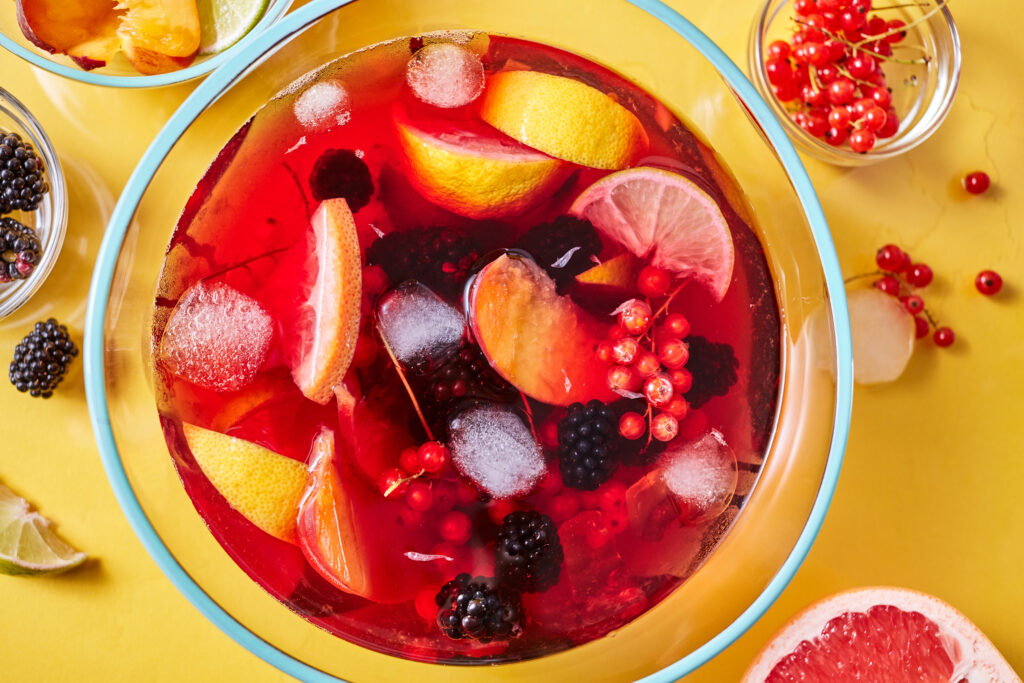 A bowl of fruit is sitting in water on the table.
